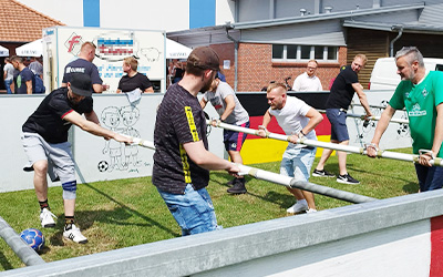 Employees play football in a human foosball table at the KURRE summer festival