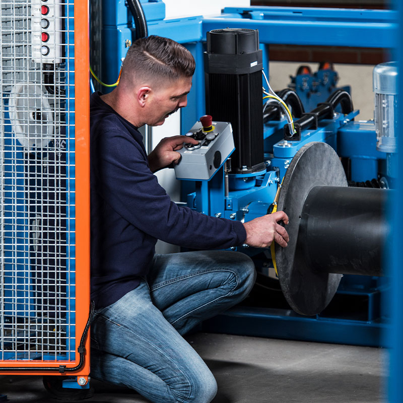 An employee checks the fit of a coil on a pintle payoff
