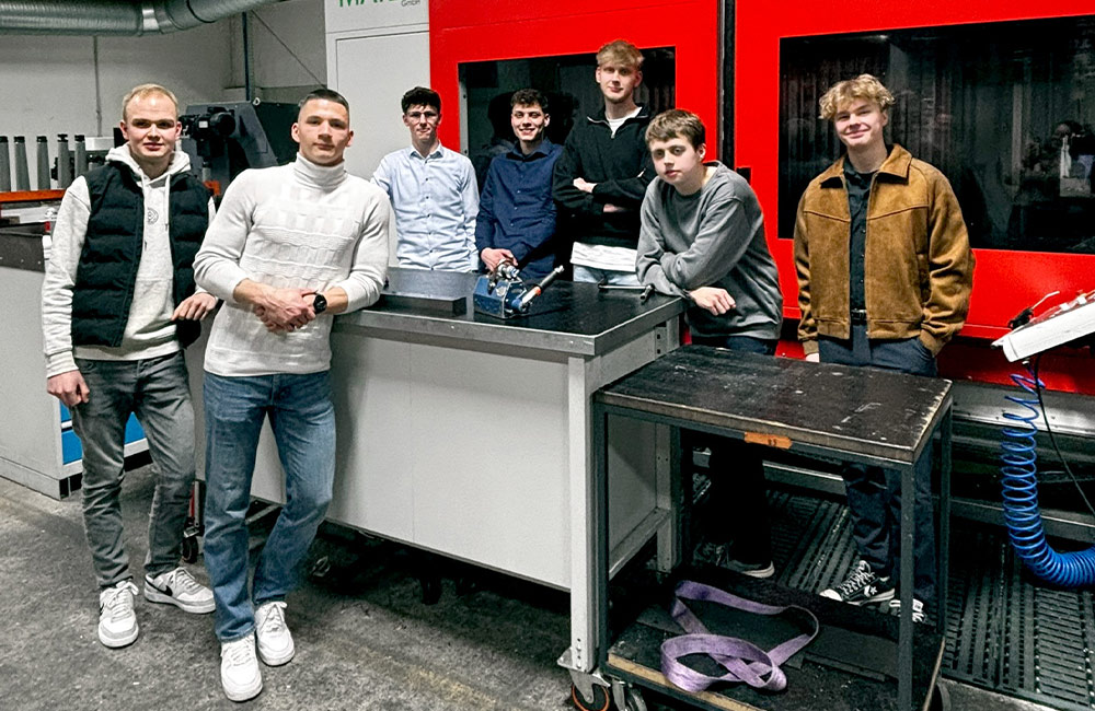 Sieben junge Männer in einer Fertigungshalle