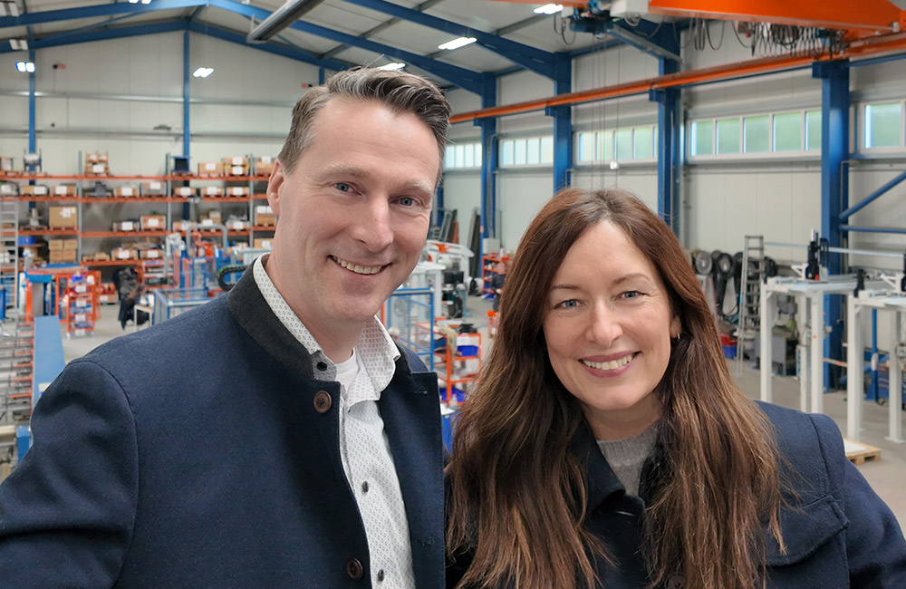 Ein Mann und eine Frau in einer Montagehalle