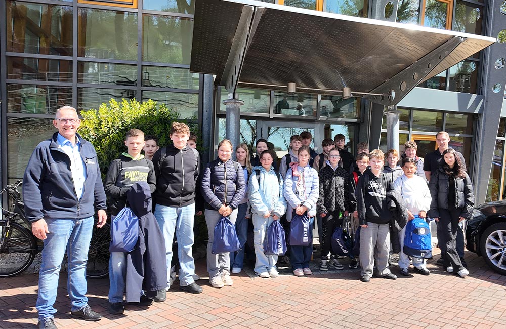 Gruppe aus 22 Kindern und 2 Erwachsenen vor einem Gebäude